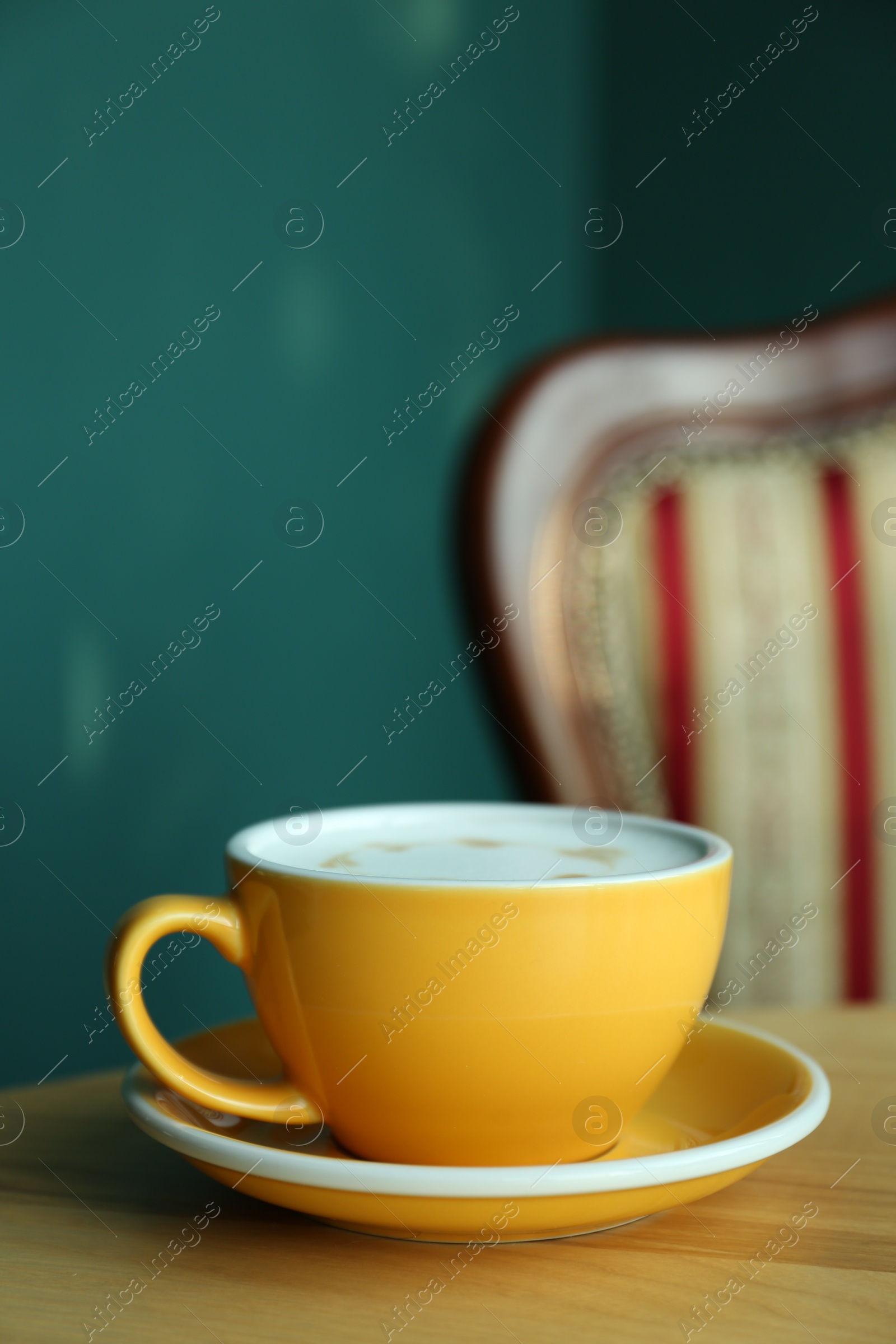 Photo of Cup of delicious coffee on wooden table indoors