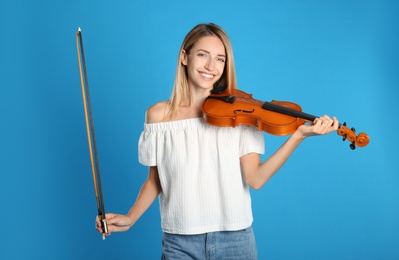 Photo of Beautiful woman with violin on blue background