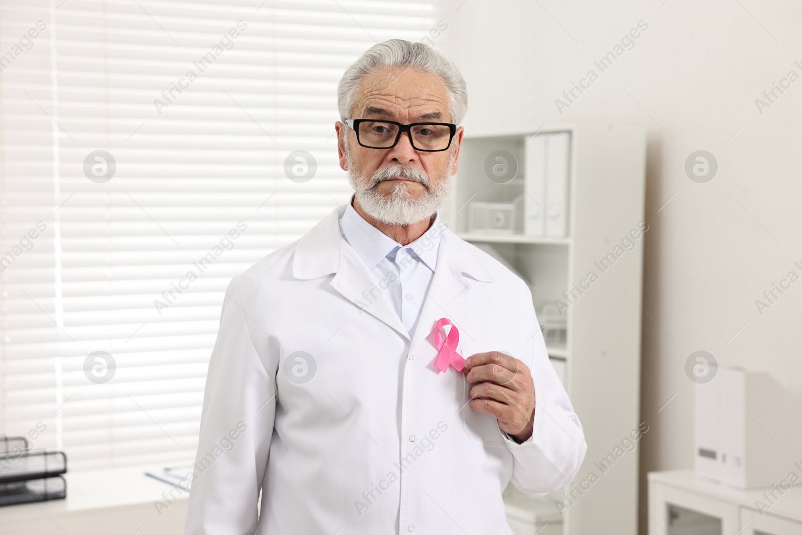 Photo of Mammologist with pink ribbon in hospital. Breast cancer awareness
