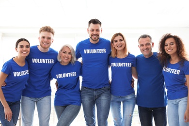 Photo of Team of volunteers in uniform on light background