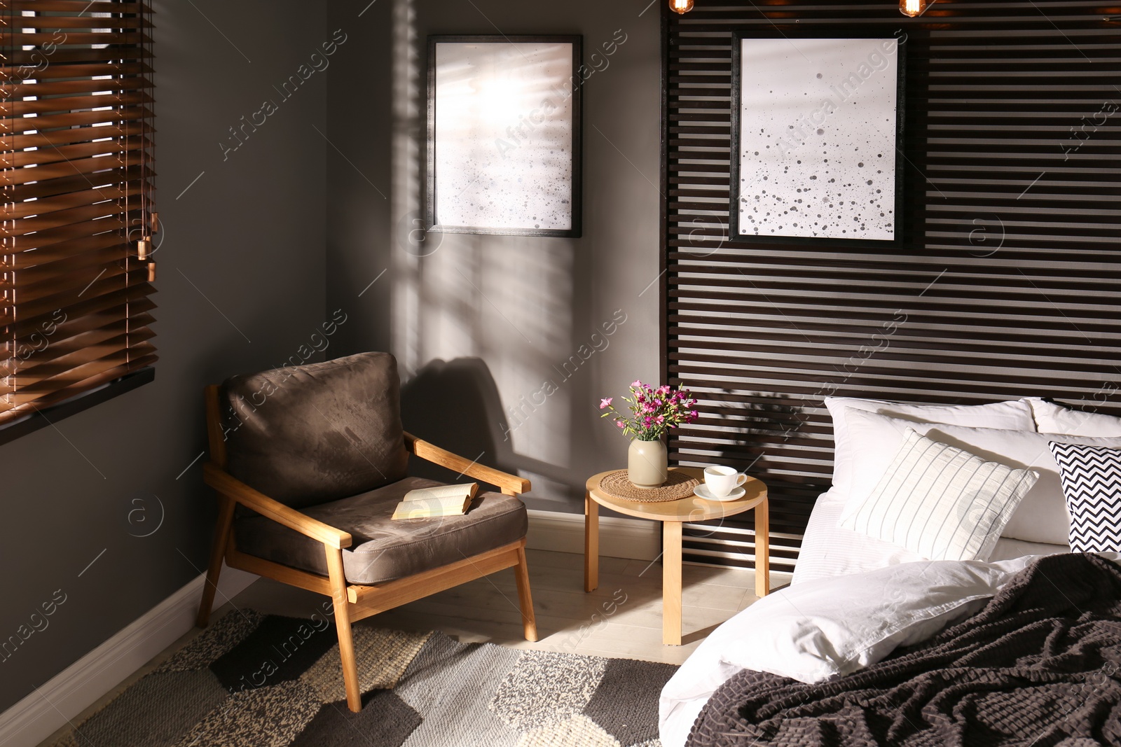 Photo of Comfortable bedroom with armchair and pictures on wall. Interior design