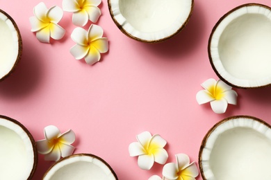 Photo of Frame made of fresh coconut halves and flowers on pink background, flat lay. Space for text