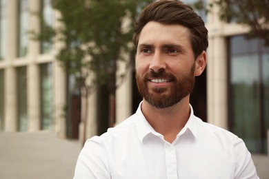 Photo of Portrait of handsome bearded man on city street, space for text