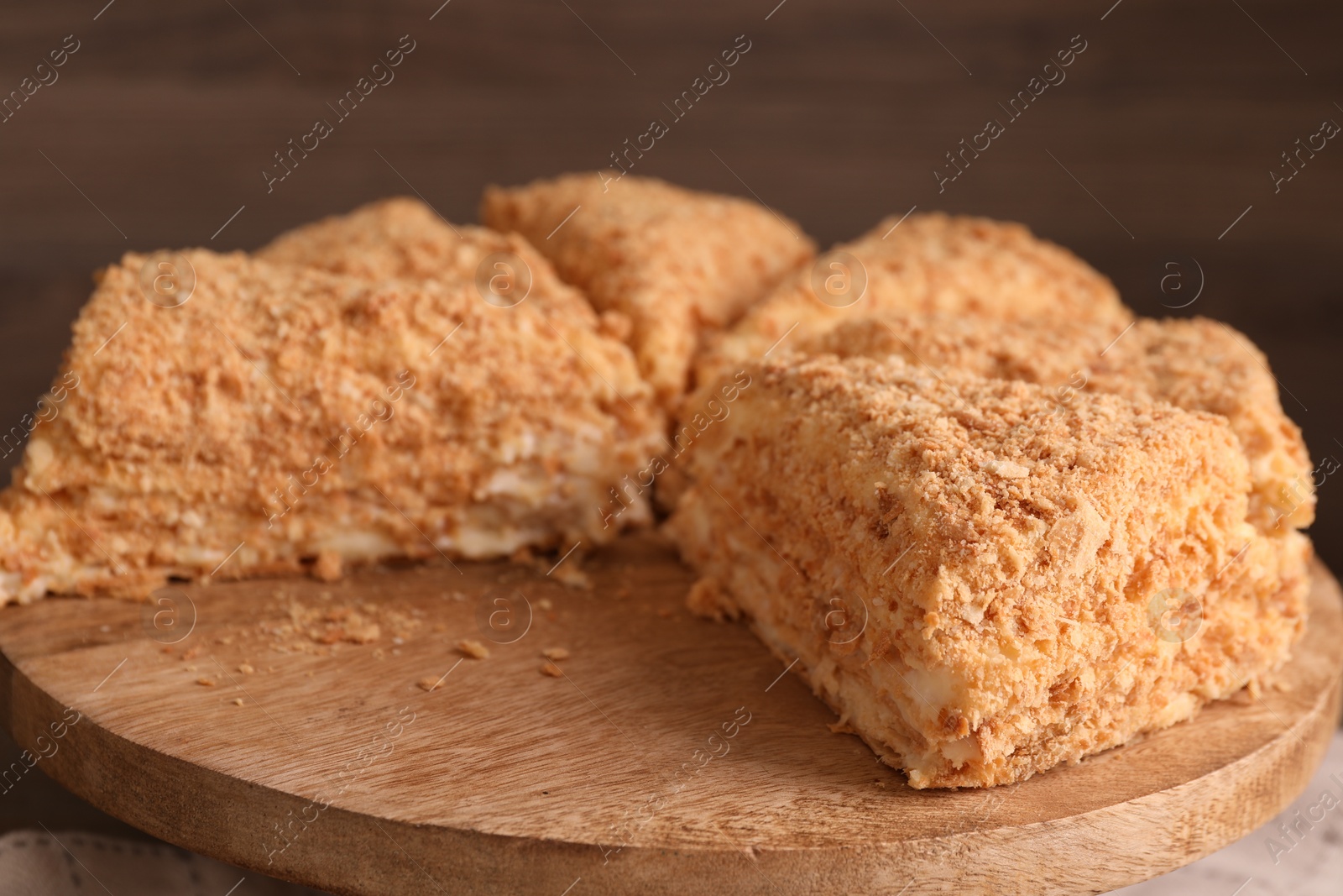 Photo of Pieces of delicious Napoleon cake on board, closeup