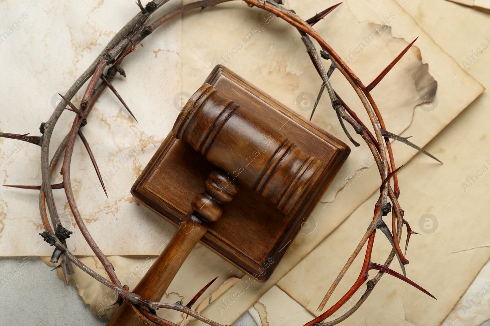 Photo of Judge gavel , crown of thorns and old paper sheets on table, flat lay