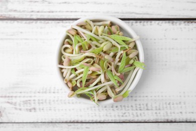 Photo of Mung bean sprouts in bowl on white wooden table, top view