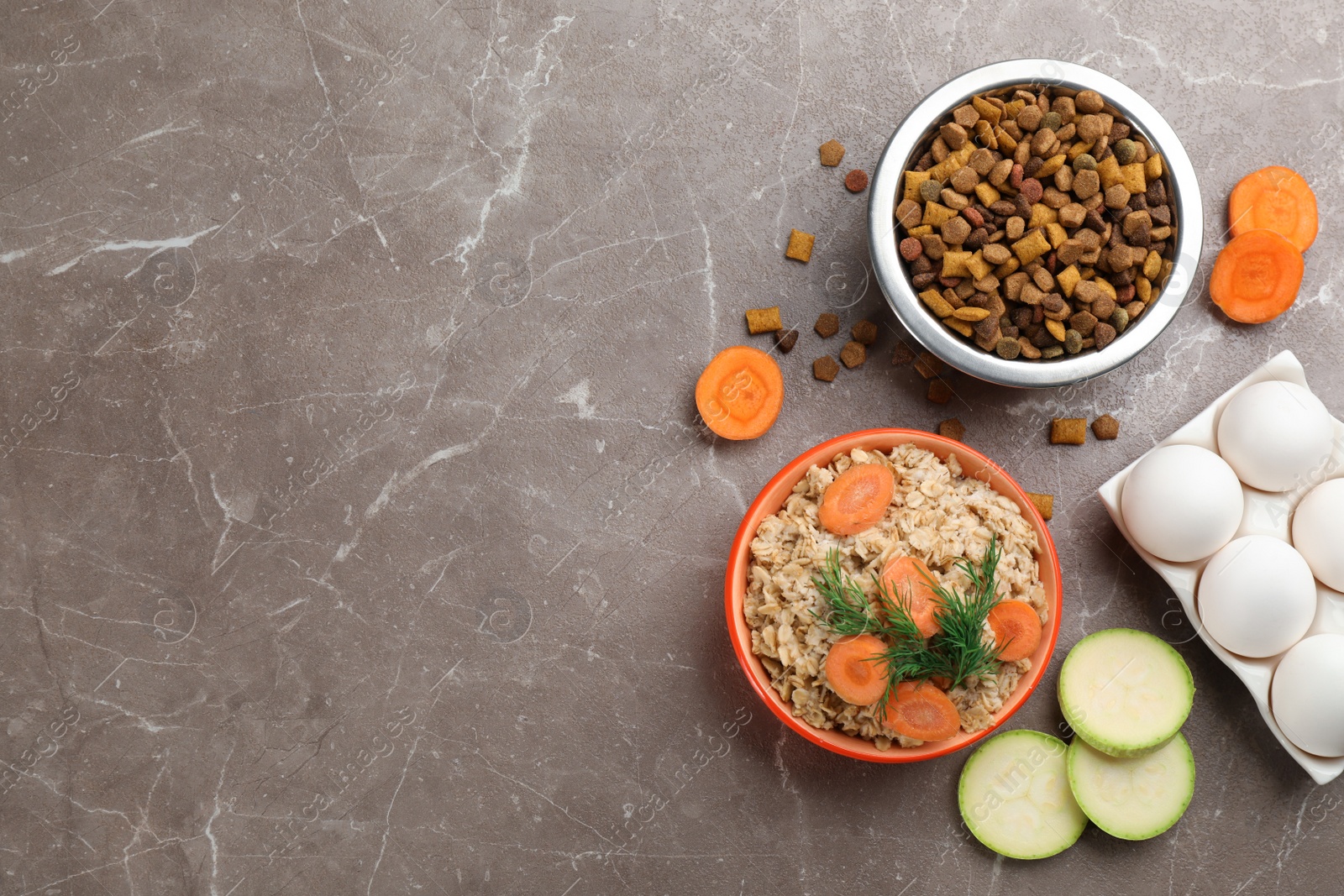 Photo of Pet food and natural ingredients on grey table, flat lay. Space for text