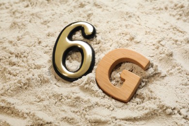 Photo of 6G technology, Internet concept. Number and letter on white sand, closeup