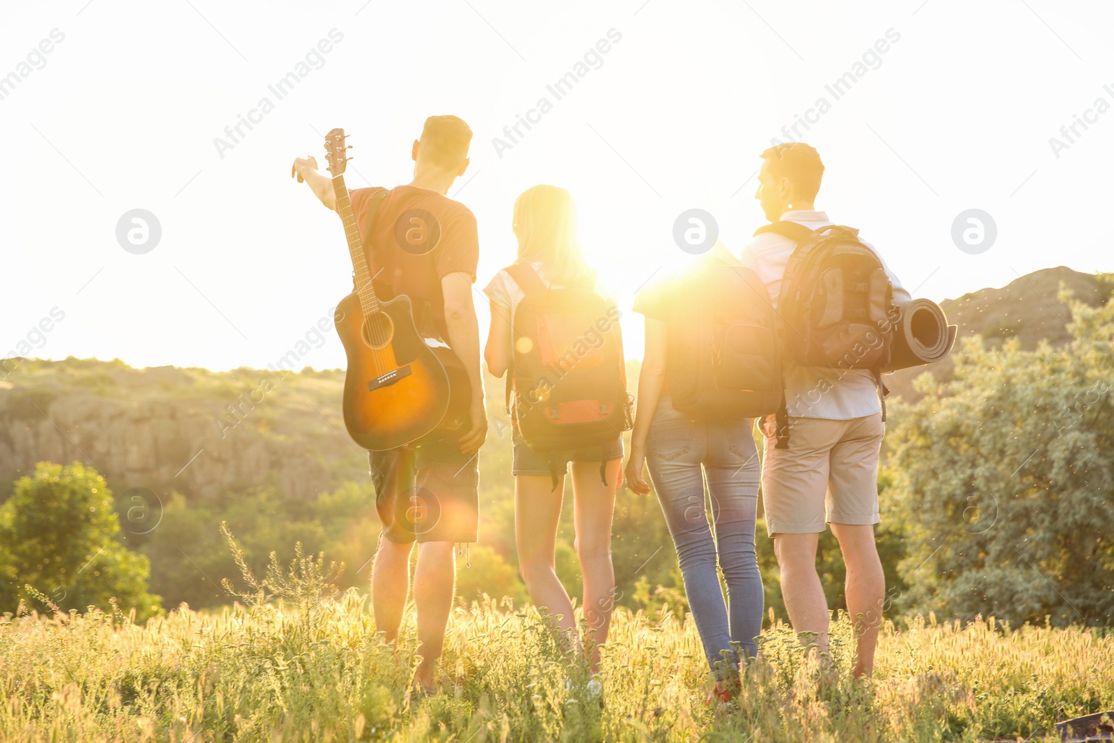 Photo of Group of young people with backpacks in wilderness. Camping season