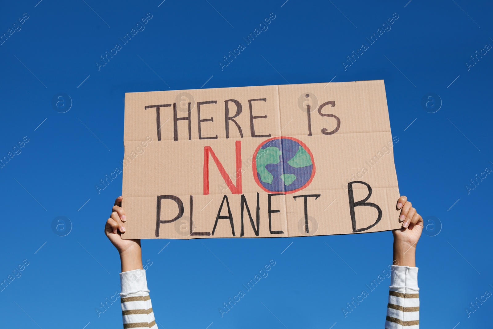 Photo of Young woman with poster protesting against climate change outdoors, closeup