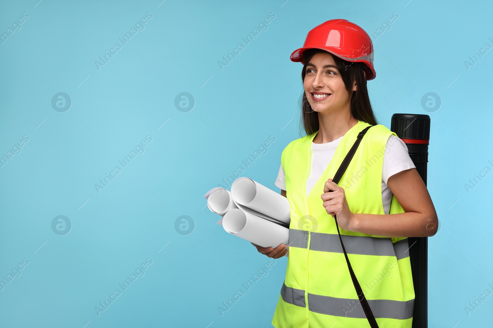 Photo of Architect in hard hat with drafts and tube on light blue background, space for text