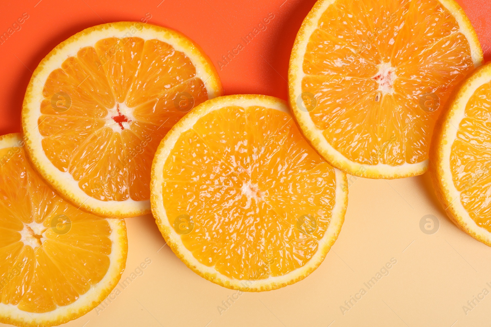 Photo of Slices of juicy orange on color background, top view