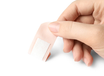 Photo of Woman putting sticking plaster on white background. First aid item