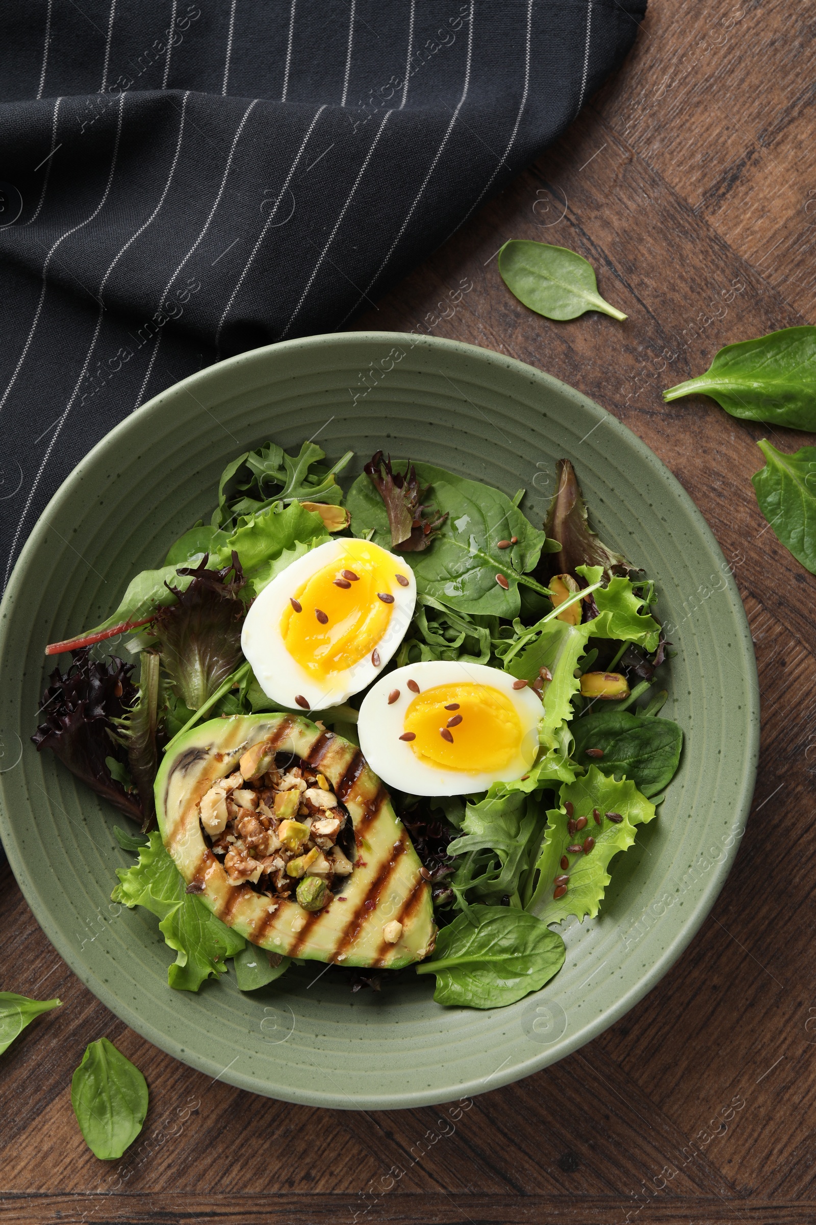 Photo of Healthy dish high in vegetable fats on wooden table, top view