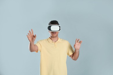 Man using virtual reality headset on grey background