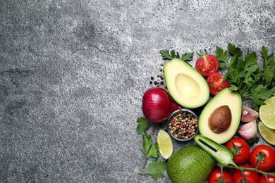 Fresh guacamole ingredients on grey table, flat lay. Space for text