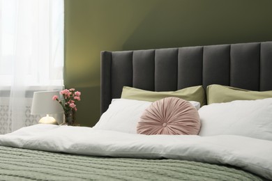Photo of Comfortable bed with pillows and duvet in stylish room. Interior design