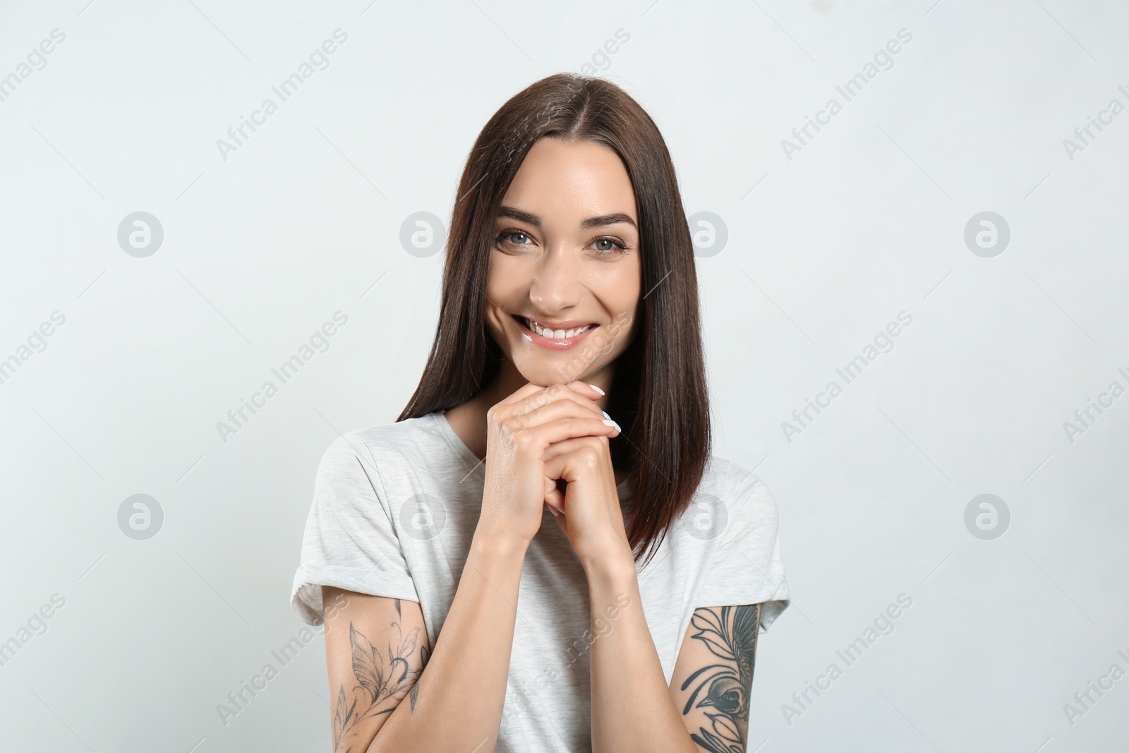 Photo of Portrait of pretty young woman with gorgeous chestnut hair and charming smile on light background