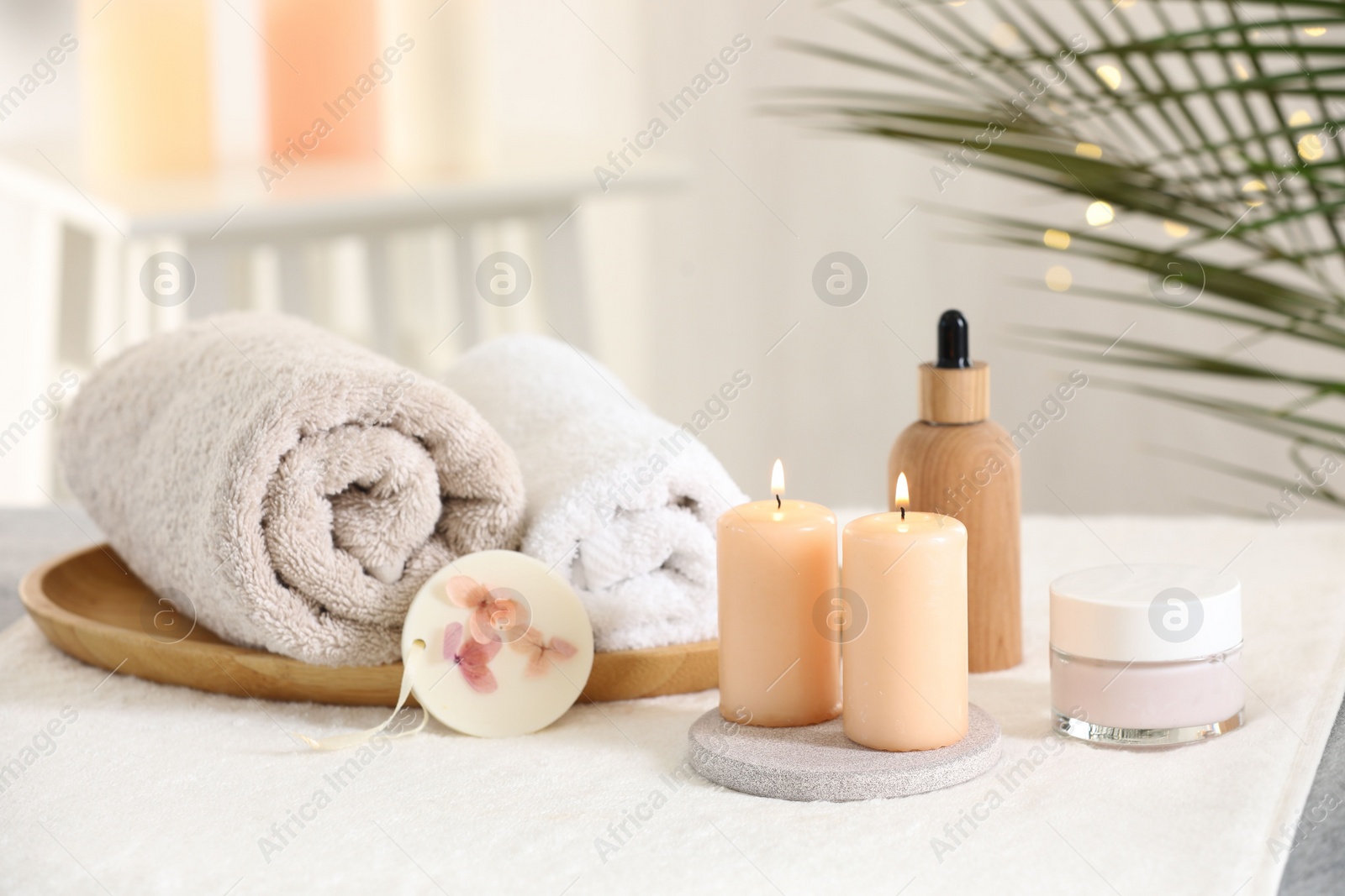 Photo of Spa composition. Burning candles and personal care products on soft surface