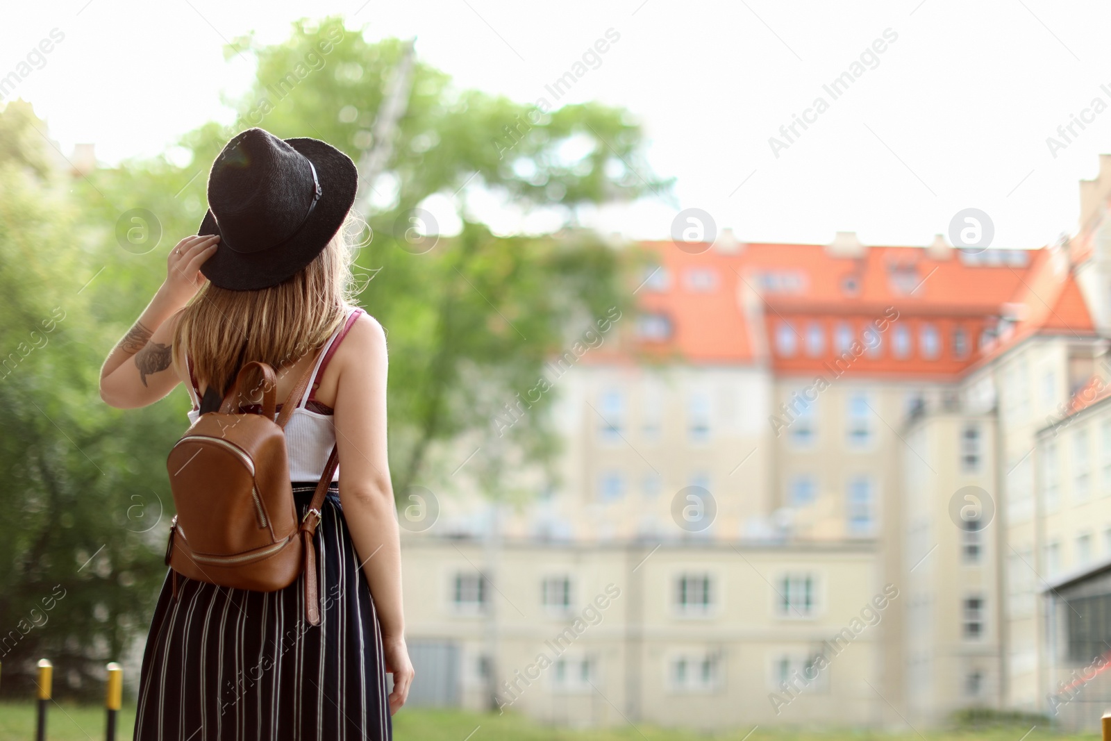 Photo of Young woman in stylish outfit on city street