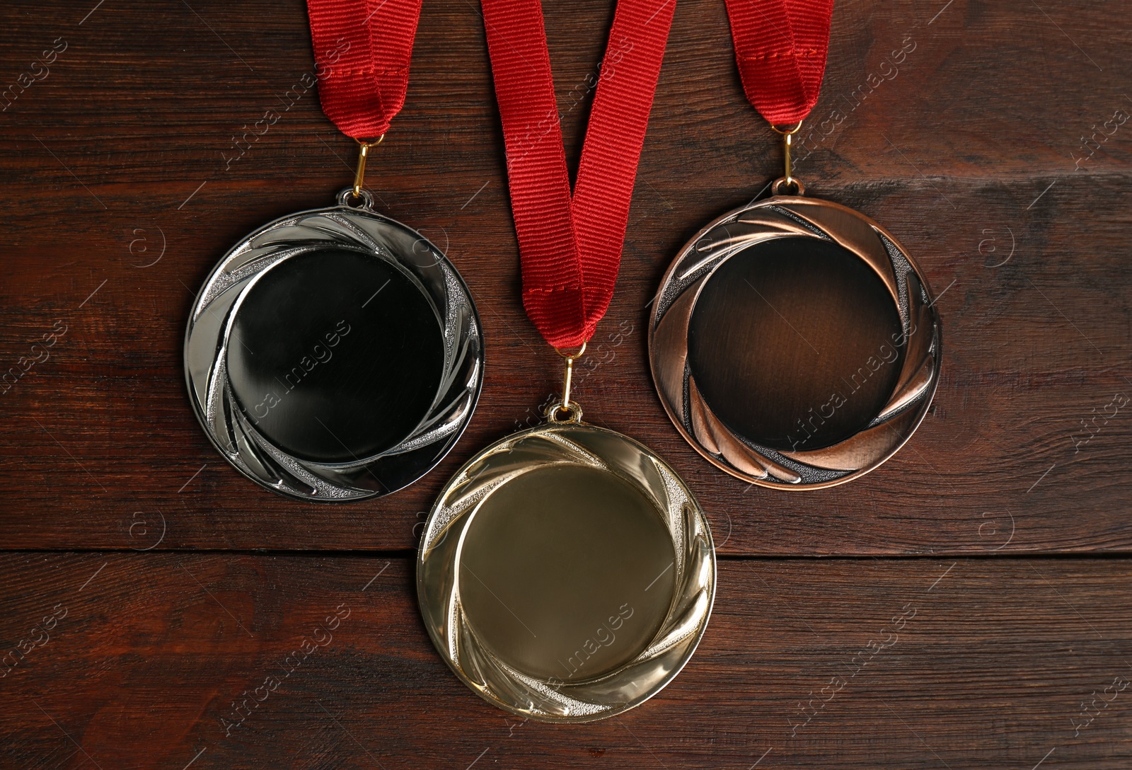 Photo of Gold, silver and bronze medals on wooden background, flat lay. Space for design