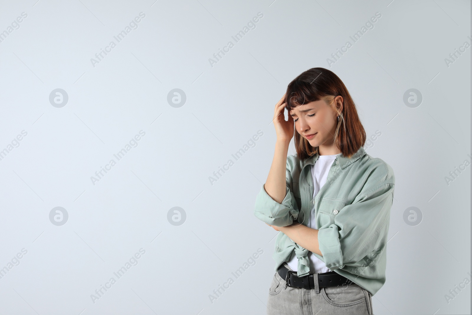 Photo of Portrait of stressed young girl on white background. Space for text