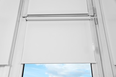 Photo of Window with white roller blinds, closeup view