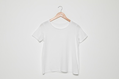 Hanger with blank t-shirt on white background. Mock up for design