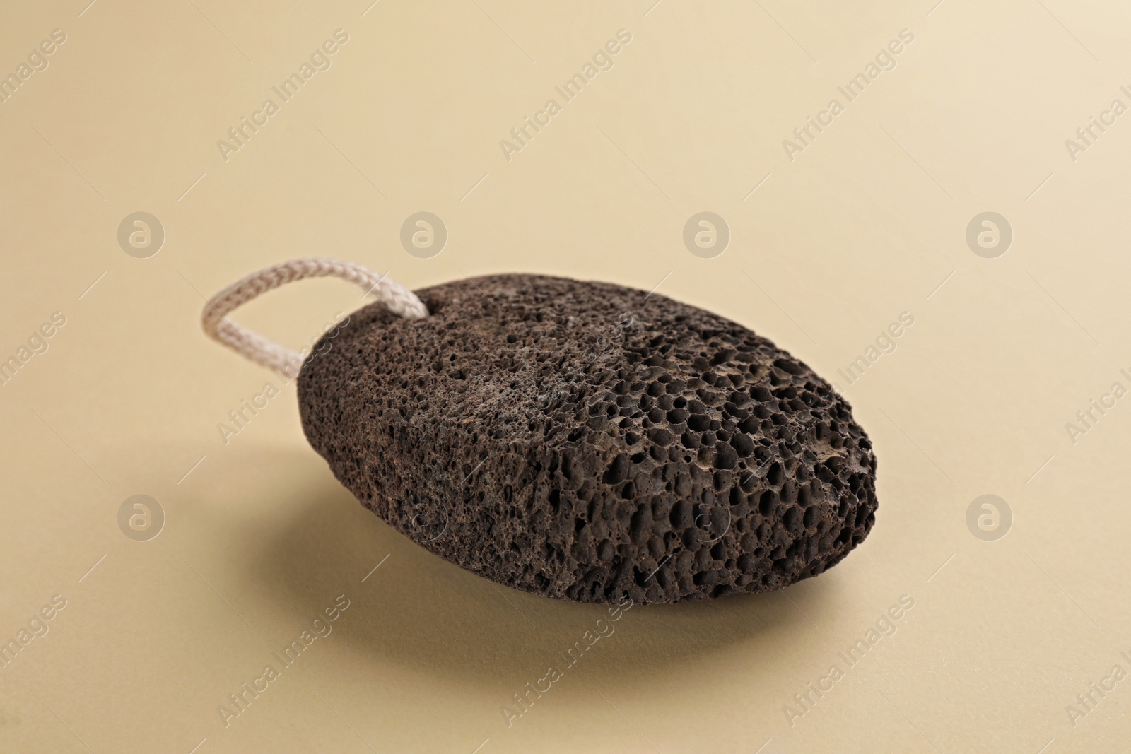 Photo of Pumice stone on beige background. Pedicure tool