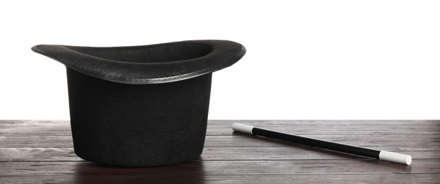 Photo of Magician's hat and wand on wooden table against white background