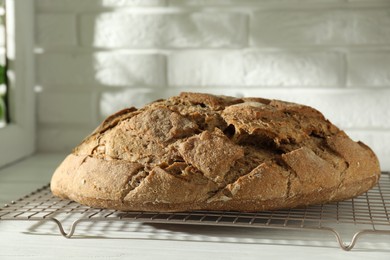 Photo of Freshly baked sourdough bread on white wooden table indoors