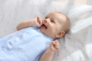 Cute little baby lying in crib at home