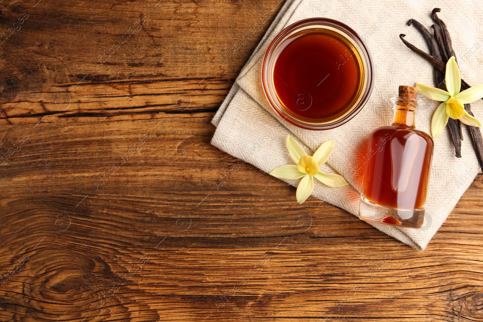 Photo of Homemade vanilla extract on wooden table, flat lay. Space for text