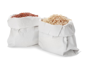 Bags with brown rice on white background