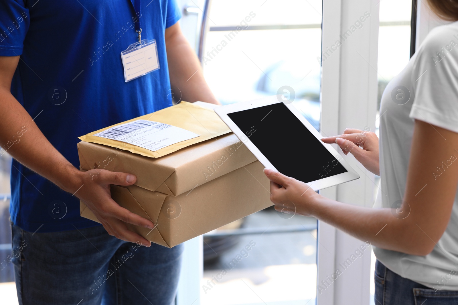 Photo of Woman using app to confirm delivery of parcel from courier on doorstep, closeup