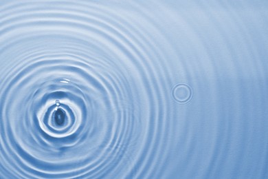 Rippled surface of clear water on light blue background, top view