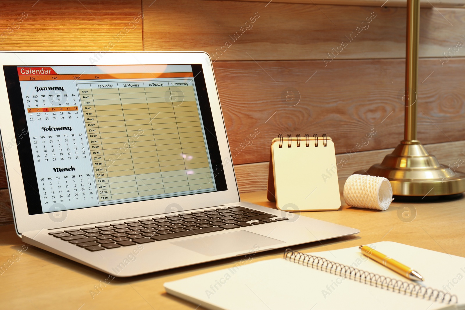 Photo of Modern laptop with calendar on screen in office