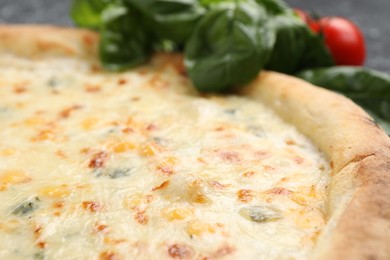 Photo of Delicious cheese pizza and basil on table, closeup