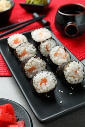Photo of Tasty sushi rolls served on grey table
