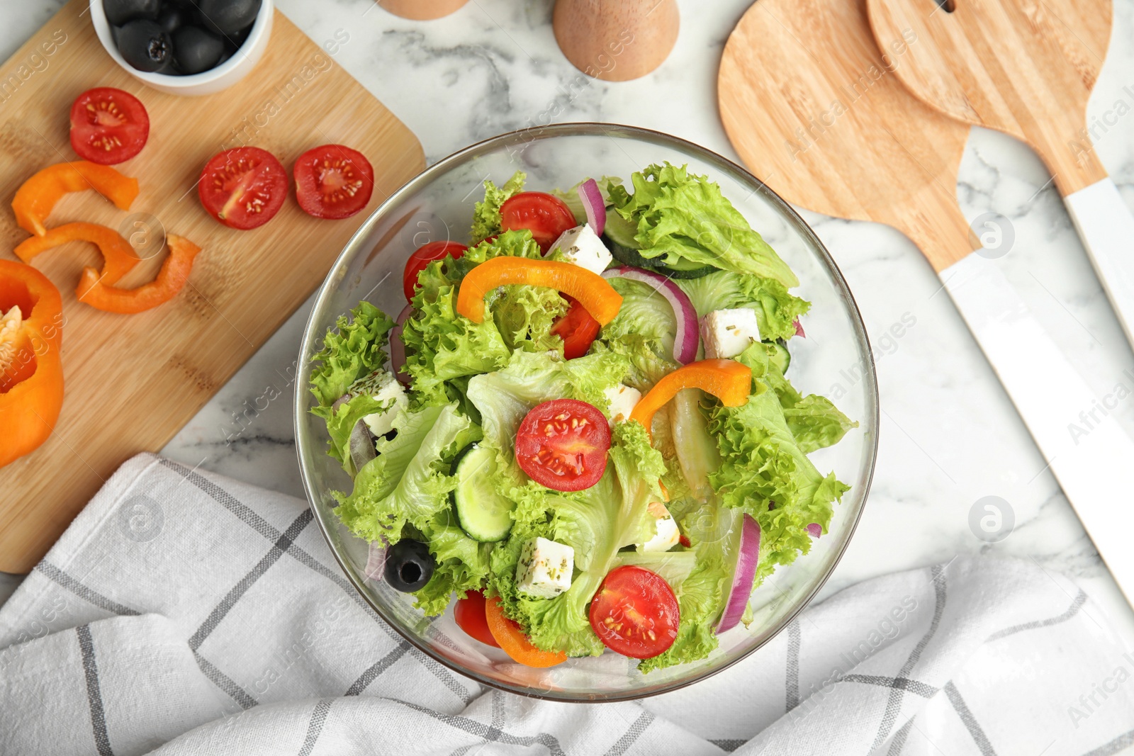 Photo of Tasty fresh Greek salad on marble table, flat lay