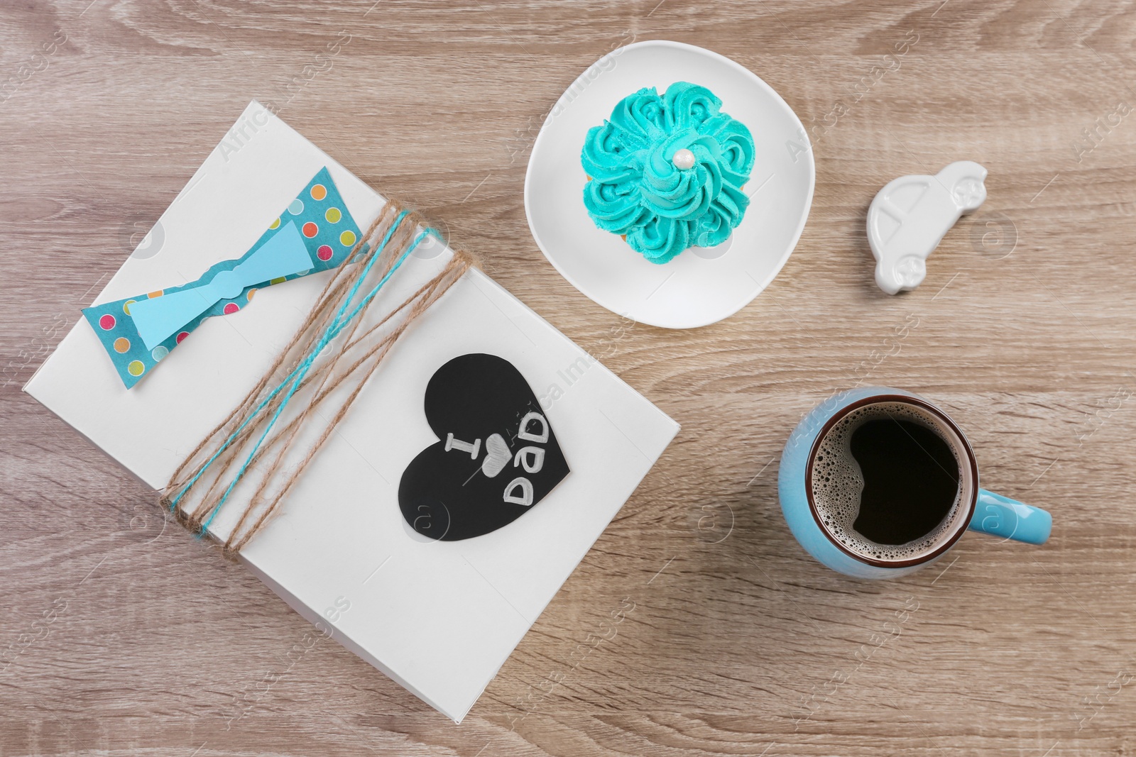 Photo of Composition with gift box and cup of coffee on wooden background. Father's day celebration