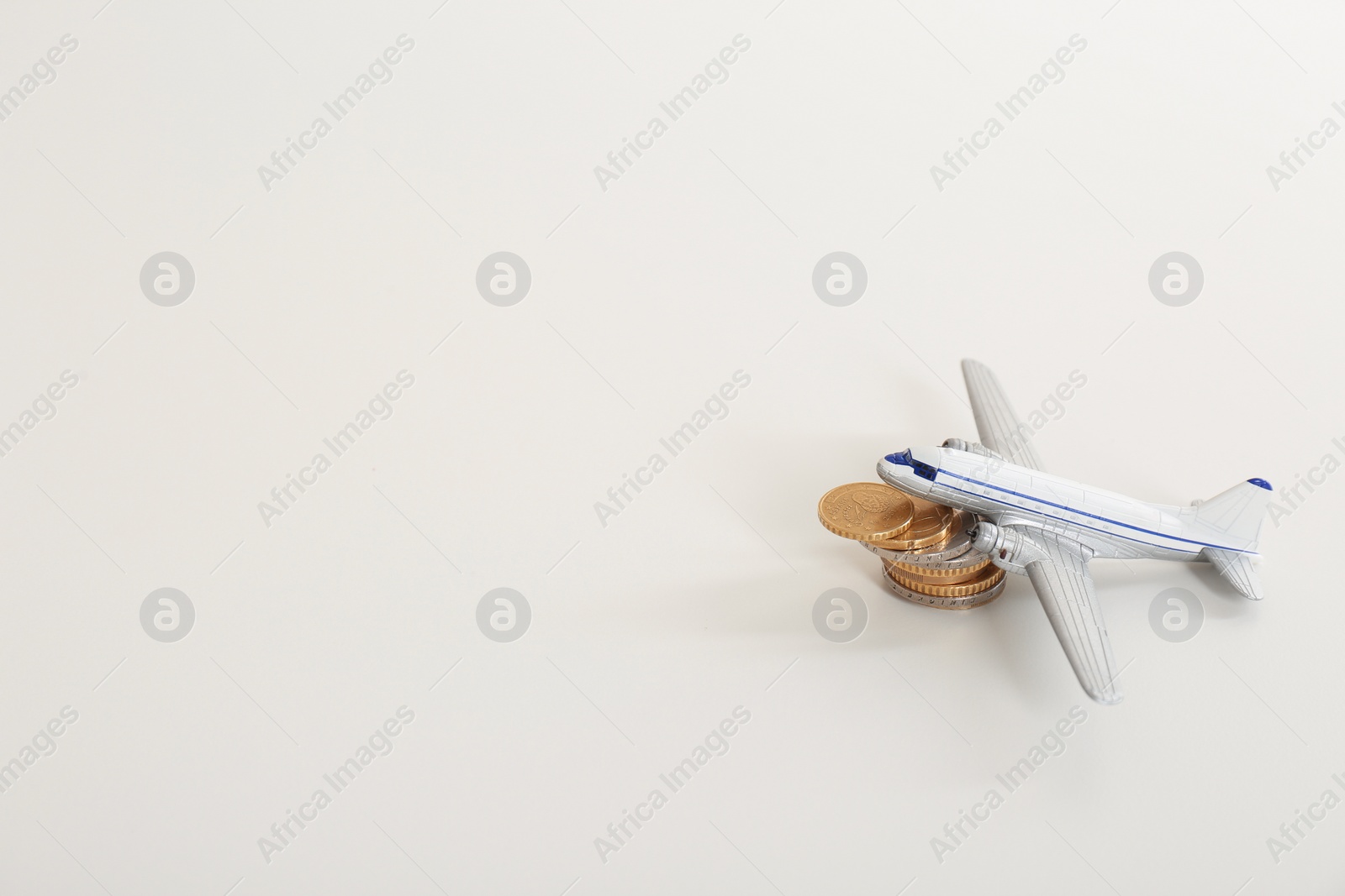 Photo of Toy plane, coins and space for text on white background. Travel insurance
