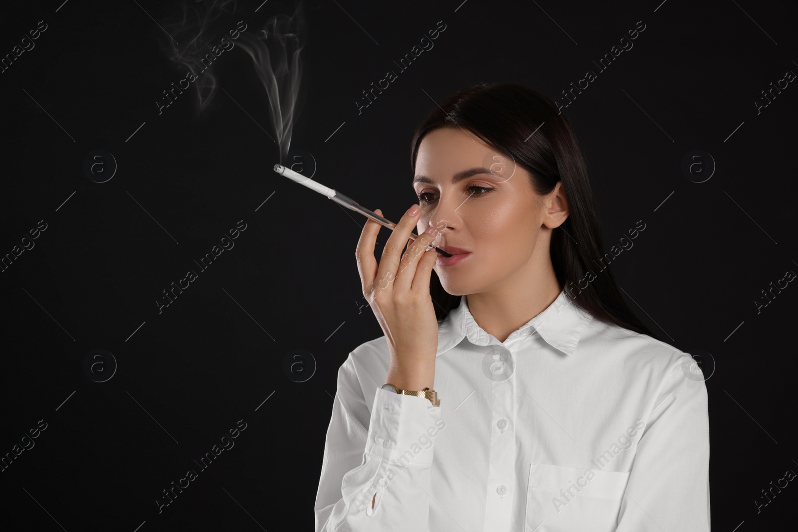 Photo of Woman using long cigarette holder for smoking on black background, space for text