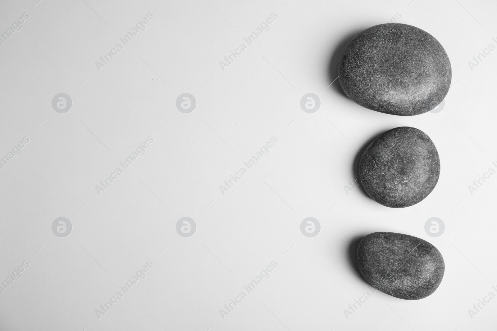 Photo of Zen stones on white background, top view with space for text