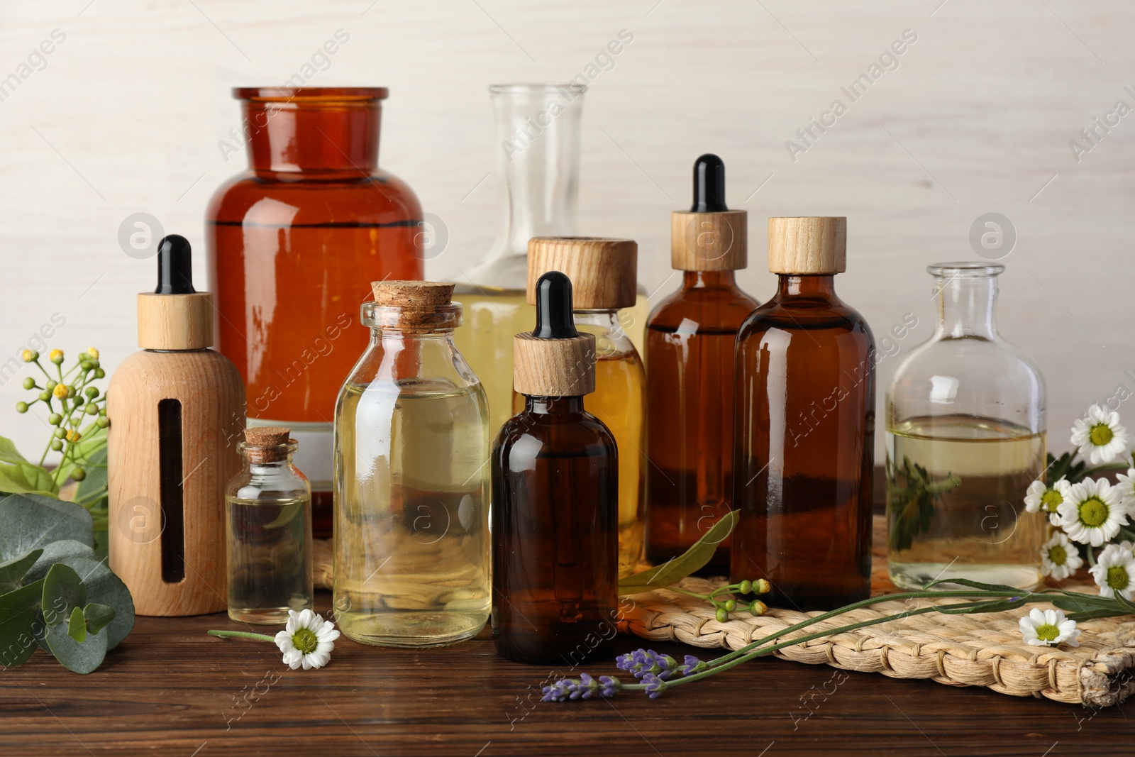 Photo of Aromatherapy. Different essential oils and flowers on wooden table