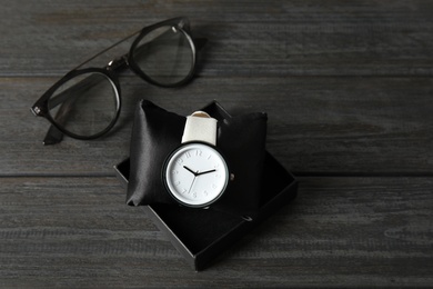 Composition with stylish wrist watch on wooden background. Fashion accessory