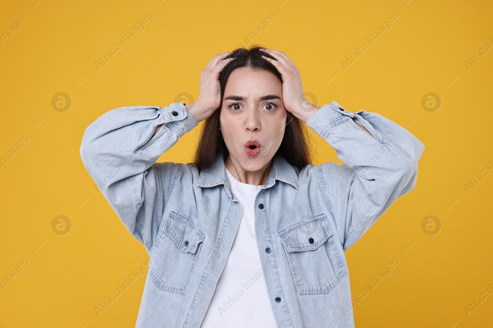 Photo of Portrait of surprised woman on orange background