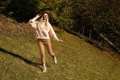 Photo of Full length portrait of beautiful young woman with hat near forest in autumn. Space for text