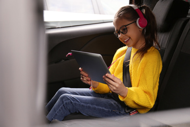 Cute little girl listening to audiobook in car