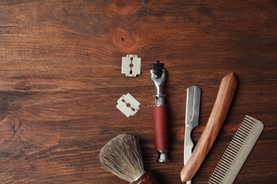 Flat lay composition with men's shaving accessories and space for text on wooden background